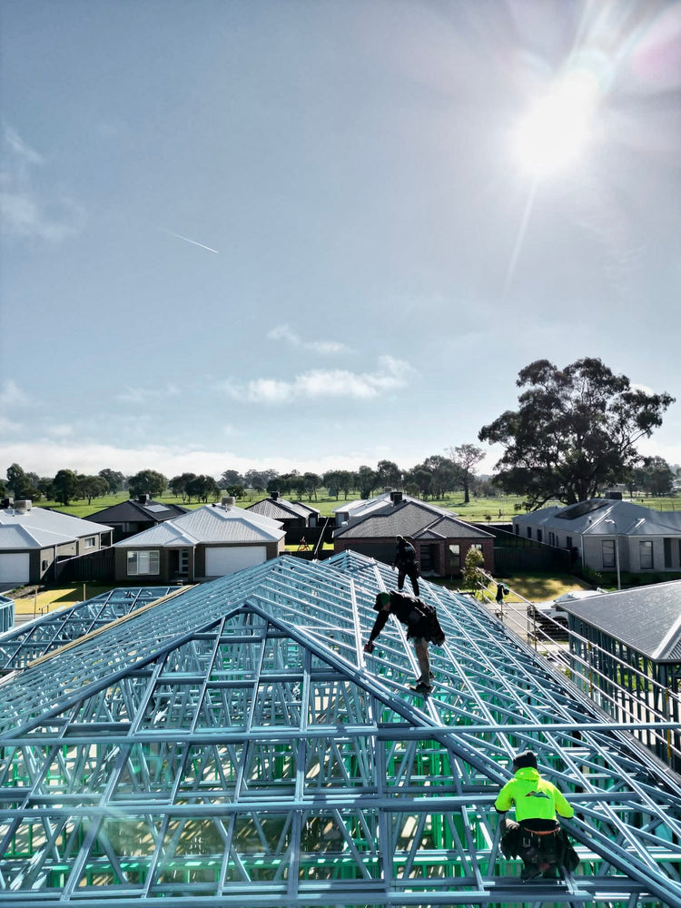 Roofers working across a new steel roof frame