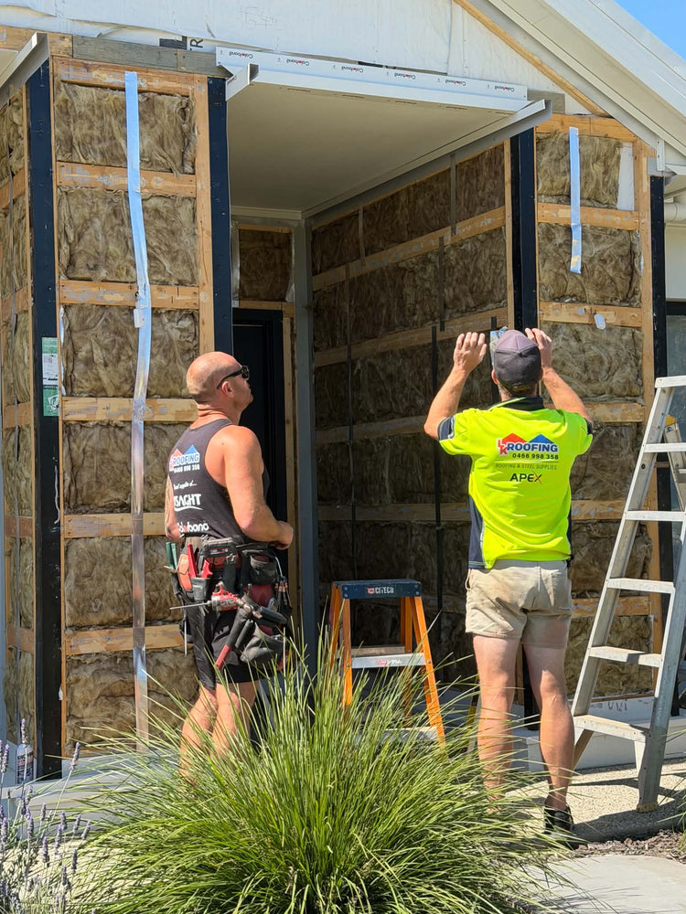 Two LK Roofing tradies fitting cladding